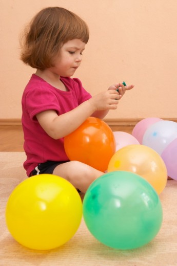 Ребенок играет воздушными шарами